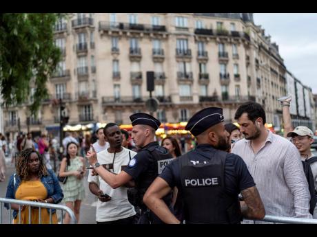 Police check the public for credentials to enter a security perimeter near the Eiffel Tower, ahead of the 2024 Summer Olympics.