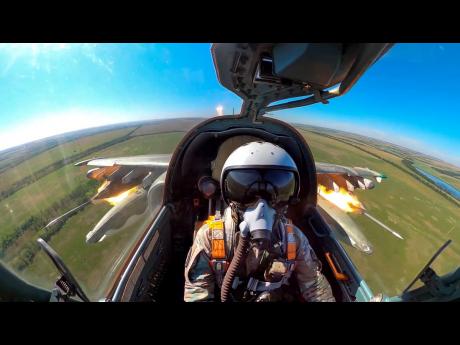 This photo, taken from video released by the Russian Defence Ministry Press Service, shows a Su-25 fighter jet firing rockets during a mission over Ukraine. 