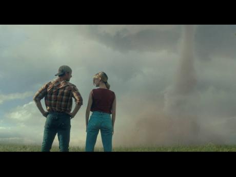 This image released by Universal Pictures shows Glen Powell (left), and Daisy Edgar-Jones in a scene from ‘Twisters’.