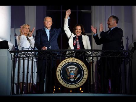 First lady Jill Biden (left) and second gentleman Douglass Emhoff (right) watch as President Joe Biden (centre, left) raises the hand of Vice President Kamala Harris as they view the Independence Day firework display over the National Mall from the balcony