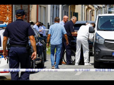 Police and forensics gather near the crime scene in Daruvar, central Croatia, yesterday. An armed assailant entered a care home for older people in central Croatia, Monday and opened fire, killing six people and wounding several others, the authorities sai