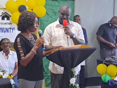 Rayon Grey (right), the president of the Cornwall Court Citizens’ Association [CCCA], is installed into the position by Yvonne Powell, vice-president of the St James Combined Association, during a ceremony held at the Cornwall Court community centre in S