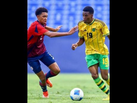 Costa Rica’s Kenay Myrie (left) chases Jamaica’s Christopher Ainsworth during a Concacaf Under-20 Championship football game at the Estadio Miguel Alemán in Mexico yesterday. 