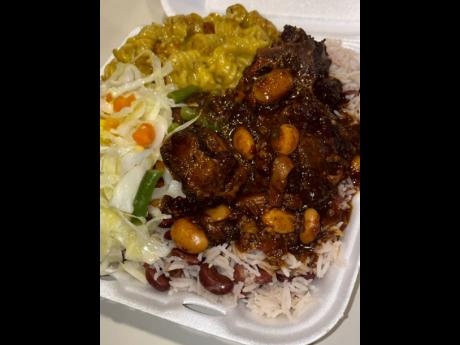 Mouthwatering oxtail with rice peas, and jerk mac and cheese. 