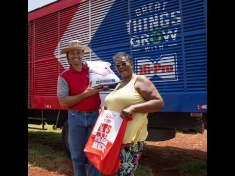 Farmer Juliet Robinson (right), of Downs District, Manchester, smiles as she receives her Hi-Pro crop kit and fertiliser from Colonel (ret’d) Jaimie Ogilvie, vice president of Hi-Pro, at the company’s recent Beryl relief initiative in St Elizabeth. On 