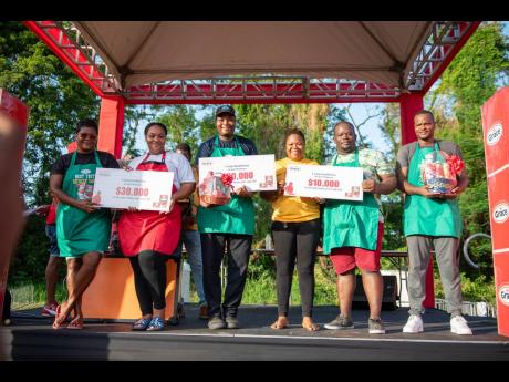 Kadian Parkins (third right), Grace Foods brand manager, poses with participants in the Grace Foods Premium Jack Mackerel Cook-off as they show off their winning symbolic cheques. From left: First-place winners Cardella Brown and her assistant, Lettanae Wh