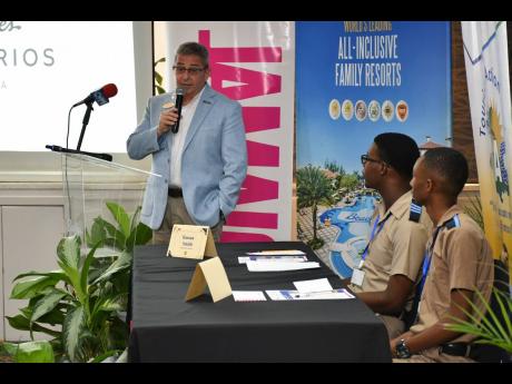 Charles Blacher (left), general manager of Beaches Ocho Rios, congratulates Hassan Smith (centre) and Taj Melbourne while bringing greetings at the final.