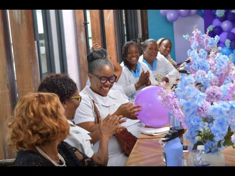 A 25-year veteran, Nurse Cassandra Jones-Watson of Cornwall Regional Hospital is all smiles after nailing the precision pop activity much to the excitement of fellow nurses attending an appreciation lunch at Sandals Montego Bay during Nurses Week.