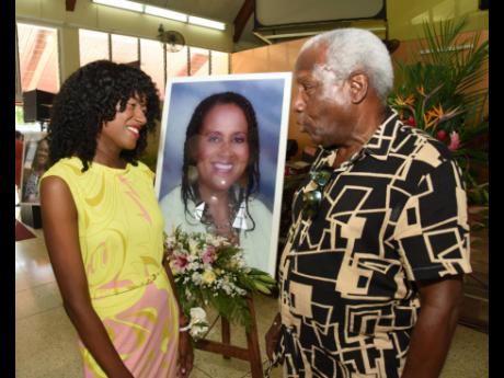 Neville Oxford (right), former national footballer, greets Dr Tarika Barrett, daughter of Betty Ann Blaine, at the service of thanksgiving for the child rights campaigner at the Boulevard Baptist Church in St Andrew on Thursday.