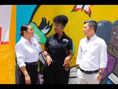 Andrea Dempster Chung (centre), executive director, Kingston Creative, speaking with donors who adopted a block on Water Lane in downtown Kingston, Tiffany Wong (left), marketing manager, Continental Bakery Limited, and Craig Hendrickson, director of sales