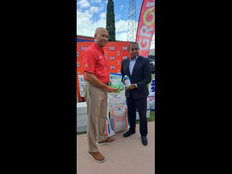 Hi-Pro vice-president, Retired Col Jaimie Ogilvie, hands over agricultural supplies to Floyd Green, minister of agriculture, fisheries and mining. 