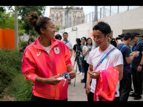 Naomi Osaka (left)  of Japan talks to a journalist after her practice session at the 2024 Summer Olympics, Thursday, July 25, 2024, in Paris, France. 