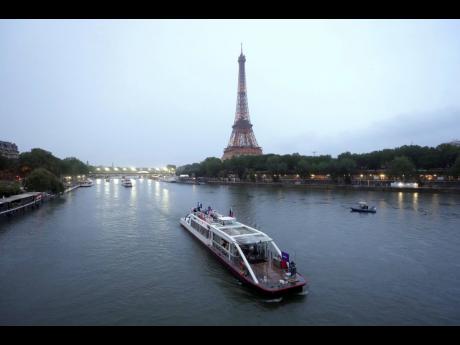 Team boats on the Seine with the Eiffel Tower in the background during the opening ceremony of the 2024 Summer Olympics in Paris.