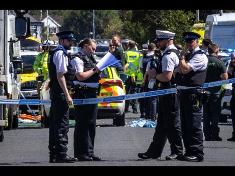 Police secure the area where a man has been detained and a knife has been seized after a number of people were injured in a reported stabbing, in Southport, Merseyside, England, on Monday.