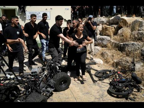 A woman from the Druze minority is overcome by emotion at the site where 12 children and teens were killed in a rocket strike on a soccer field, during a visit by Israeli Prime Minister Benjamin Netanyahu in the village of Majdal Shams, in the Israeli-anne