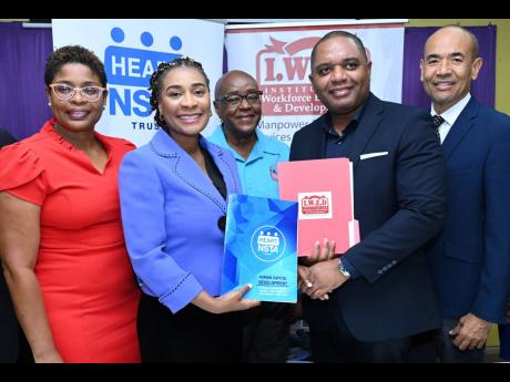 Dr Taneisha Ingleton (second left), managing director of the HEART/NSTA Trust and Don Gittens (right), chief executive officer of IWED, with the signed memorandum of understanding between the two entities while looking on from left are Kenesha Campbell, di