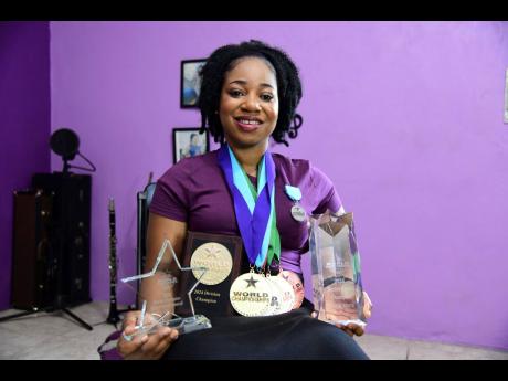 Andrene Brown shows off the awards she won at the recent World Championships of Performing Arts in the United States.