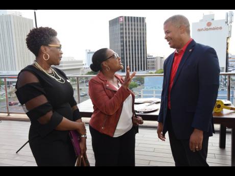 Grace Burnett (centre), chief executive officer, GK Financial Group, had the attention of Frank James, chief executive officer, Grace Foods – Domestic, and Sacha Vaccianna-Riley, executive director, the Private Sector Organisation of Jamaica. 