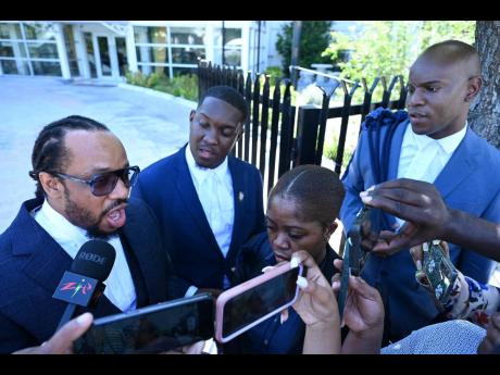 Attorney Isat Buchanan (left) with Vybz Kartel’s other lawyers – attorneys-at-law JIqbal Cheverria (second left), John Clarke, and Alessandra Labeach – speak with the media after the Court of Appeal’s ruling. 