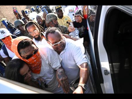 Dancehall superstar Vybz Kartel leaving the Tower Street Adult Correctional Facility after being set free by the Court of Appeal. With him are his fiancée, Sidem Oztürk, and Tommy Thompson of Brite Lite Funeral Home.