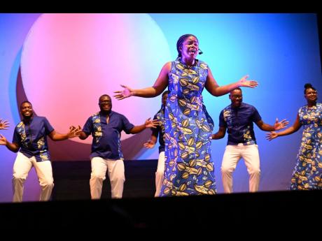 Dressed splendidly in African print outfits, the women of the NDTC Singers, with some of the men behind, perform at the Little Theatre.