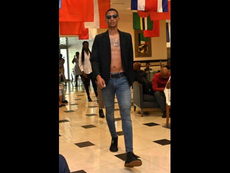 In a black blazer over a toned torso and black shoes to match, this SAINT model embodies the high- fashion runways of Paris at The Jamaica Pegasus’ Olympic Village Fashion Parade.