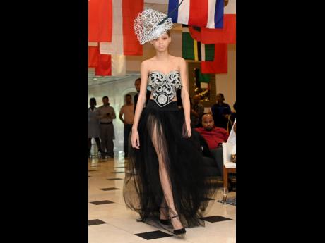 A Kadian Nicely black tulle gown pairs seamlessly with a white and black fascinator by Karl Brown.