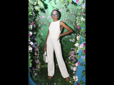 Like a striking white lily in a garden, Lea-Andrea Grant stands out in a chic white jumpsuit.