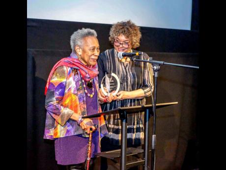 Veteran community activist Dawn Hill CBE (left) receives the Paulette Wilson Justice Award from Windrush Caribbean Film Festival co-founder Frances Anne Solomon at the closing ceremony in Brixton.