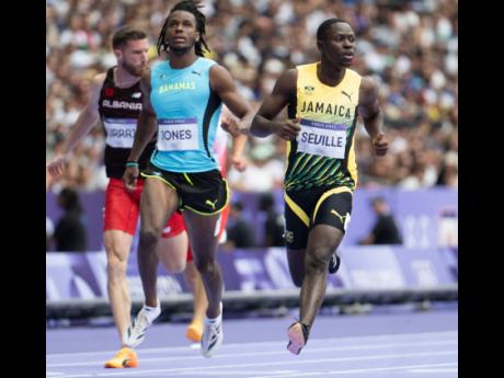 Jamaica’s Oblique Seville looks at the clock after completing his 100-metre heat at the Stade de France yesterday.