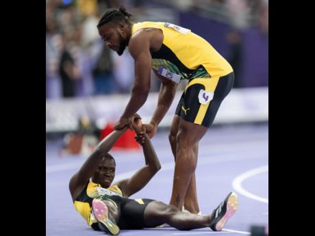 2. Kishane Thompson (left) assists teammate Oblique Seville of Jamaica moments after the men’s 100m finals.