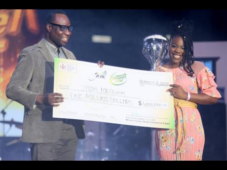 Permanent Secretary in the Ministry of Culture, Gender, Entertainment and Sport, presents the winning trophy and cheque to a beaming Jaida Messam.