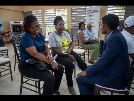 From left: Melrose McLean and Christine Dandy, members of JN Bank Ocho Rios, have a discussion with Ricardo Dystant, chief, JN Bank Operations and  IT, at the Ocho Rios leg of the JN Members’ Meeting, held recently at the St Johns Anglican Church Hall.