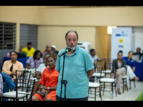 Adam Albanowicz, a member of the JN Bank Ocho Rios branch, asks a question after the presentations.