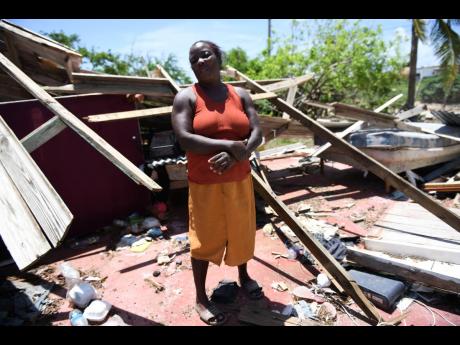 A resident of Portland Cottage, Clarendon shows what is left of her son’s home which was destroyed by Hurricane Beryl.