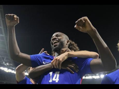 France’s Jean-Philippe Mateta celebrates with teammates after scoring his team’s second goal  in extra-time during the men’s semifinal football match against Egypt at the 2024 Olympic Games in Lyon, France, yesterday. 