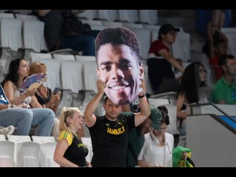 A Jamaican supporter holds up a picture of diver Yona Knight-Wisdom during the preliminary round of the three-metre springboard at Aquatic Centre in Paris, France, yesterday.