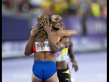 St Lucia’s Julien Alfred congratulates 200-metre Olympic champion Gabby Thomas even as she celebrates her silver medal in the event at the Stade de France yesterday.