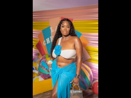 Hairstylist Corolla Johnson exuded confidence in a white bikini adorned with blue flower accents and matching centre-slit skirt.