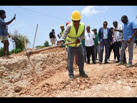 Prime Minister Andrew Holness (centre); James Robertson (left), member of parliament for St Thomas Western; Varden Downer (second right), senior director, National Works Agency (NWA); and Robert Morgan (right), minister of works, look on as a workman from 