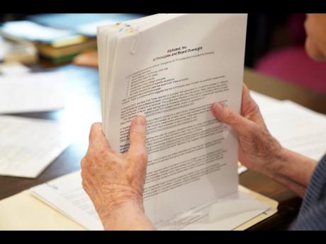 Sister Barbara McCracken looks through prior resolutions filed against various corporations, including Alphabet, Meta, Netflix and Chevron, at the Mount St Scholastica Benedictine monastery in Atchison, Kansas, on Tuesday, July 16, 2024.