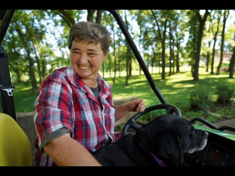 Sister Elaine Fischer rides through the Mount St Scholastica Benedictine monastery grounds with Sophie, the community’s dog, on Wednesday, July 17, 2024 in Atchison, Kansas.