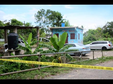 
A scene of crime tape cordons off Cherry Tree Lane in Clarendon where eight people were gunned down in a drive-by shooting.