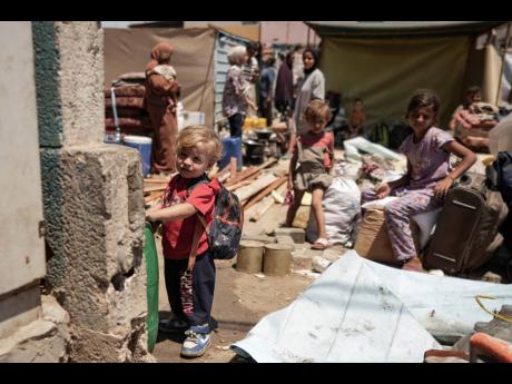 Palestinian children wait to evacuate a school that had been their shelter, in eastern Deir al-Balah, Gaza Strip.