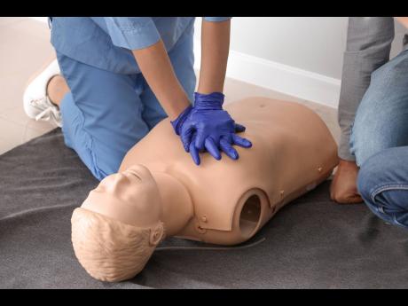 Representative image of an instructor demonstrating CPR on a mannequin. 