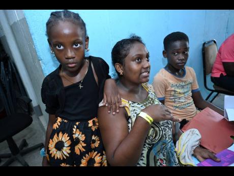 Latoya Mitchell explains how she was able to make the back-to-school season less burdensome as her children Kadasis Wright and Tarick Wright listen.