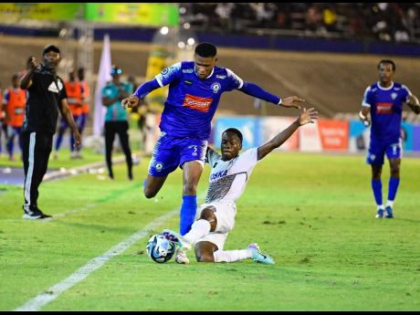 Dwayne Atkinson (right) of Cavalier SC  tackles Gawain Austin of Mount Pleasant FA during the May 19, 2024 Jamaica Premier League  final at the National Stadium. 