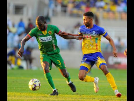 Xavian Virgo (left), tries to lose the attentions of Harbour View’s Timar Lewis during a Jamaica Premier League game for Humble Lion last season.