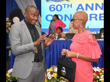 Dr Mark Smith, president of the Jamaica Teachers’ Association, speaking with Fayval Williams, minister of education and youth. 