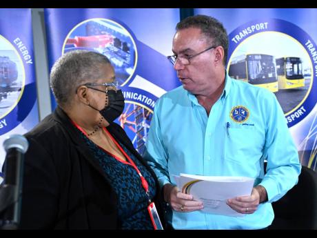 Daryl Vaz, minister of science, energy, telecommunications and transport, speaks with Carol Palmer, permanent secretary in the ministry, after addressing a press conference on recent developments concerning the Jamaica Public Service Company Ltd and electr